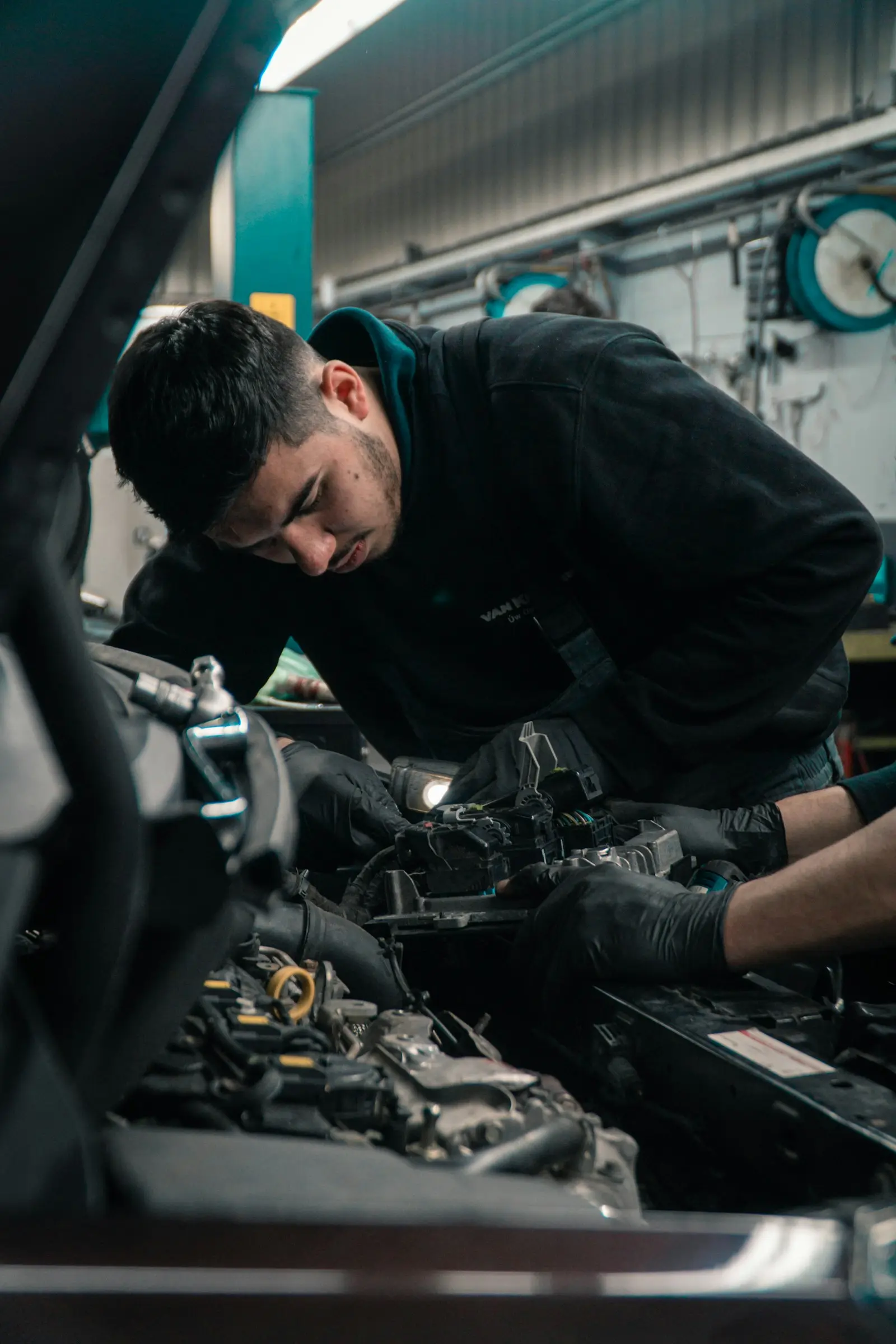 Mecánico con guantes trabajando en el motor de un auto